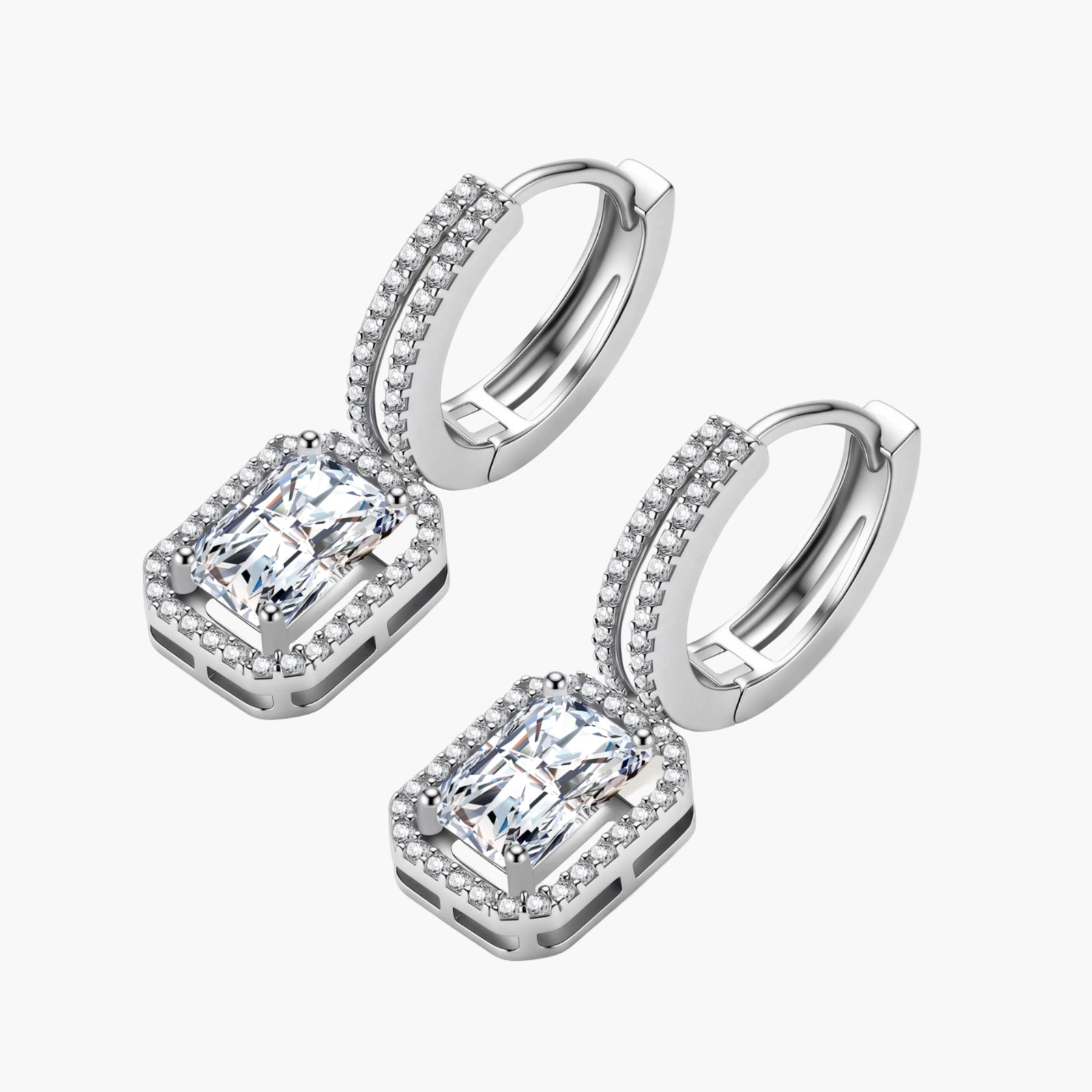 Sterling silver huggie hoops with emerald-cut moissanite drops featuring pavé-set crystals on white background.